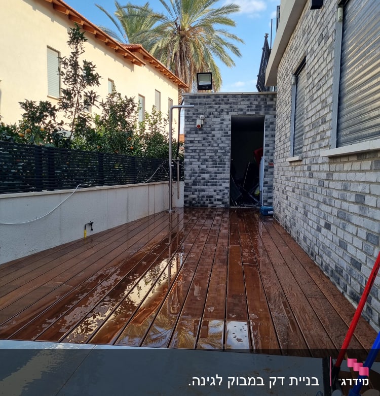 מרפסת עץ רטובה עם מטאטא ומגב